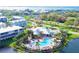 An aerial view of a community clubhouse and pool surrounded by lush landscaping and a scenic pond at 10311 Lands End Cir # 16, Placida, FL 33946