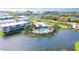 Aerial view of a community clubhouse and pool surrounded by lush landscaping and a scenic pond at 10311 Lands End Cir # 16, Placida, FL 33946