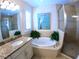 Bright bathroom features a soaking tub, glass-enclosed shower, and granite vanity at 10311 Lands End Cir # 16, Placida, FL 33946