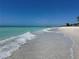 Sandy beach view with clear blue water where the waves gently crash at 10311 Lands End Cir # 16, Placida, FL 33946