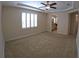 Spacious carpeted bedroom with plantation shutters and tray ceiling with ceiling fan at 10311 Lands End Cir # 16, Placida, FL 33946