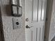 Close-up of the front door with a doorbell, light switches, and a brass handle at 10311 Lands End Cir # 16, Placida, FL 33946