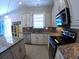Well-lit kitchen featuring granite countertops, stainless appliances, tile backsplash and cabinetry at 10311 Lands End Cir # 16, Placida, FL 33946