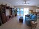 Bright living room with a blue sofa, an entertainment center, and a sliding glass door leading to a balcony at 10311 Lands End Cir # 16, Placida, FL 33946