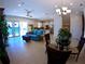 Open-concept living room with tile flooring, a blue sofa, and a view of the kitchen and dining area at 10311 Lands End Cir # 16, Placida, FL 33946