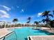 Beautiful community pool with palm trees and plenty of lounge chairs at 10311 Lands End Cir # 16, Placida, FL 33946