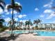 Community pool area with palm trees, lounge chairs and sunny skies at 10311 Lands End Cir # 16, Placida, FL 33946