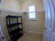 Functional walk-in closet with shelving units, a window for light, and beige tile floors at 10311 Lands End Cir # 16, Placida, FL 33946