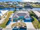 Aerial view of single-Gathering home with circular drive, screened-in pool, and private boat dock on canal at 121 Sinclair Se St, Port Charlotte, FL 33952