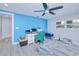 Bedroom with blue accent wall, ceiling fan, and gray wood-look floors at 121 Sinclair Se St, Port Charlotte, FL 33952