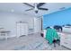 Bedroom with blue accent wall, ceiling fan, and gray wood-look floors at 121 Sinclair Se St, Port Charlotte, FL 33952