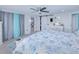 Bright main bedroom featuring a patterned comforter, a ceiling fan and an ensuite bathroom at 121 Sinclair Se St, Port Charlotte, FL 33952