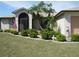 Attractive home with manicured lawn, front garden, and a charming entrance with an arched doorway at 1247 Petronia St, North Port, FL 34286