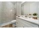 Modern bathroom with double vanity, white marble countertops, tiled shower, and wood-look tile flooring at 13356 Rayburn Ln, Port Charlotte, FL 33981