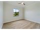 Empty bedroom featuring a ceiling fan, wood look tile flooring and a large window at 13356 Rayburn Ln, Port Charlotte, FL 33981