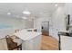 Open kitchen features stainless steel appliances, a large island with white countertop, pendant lighting, and wood-style tile flooring at 13356 Rayburn Ln, Port Charlotte, FL 33981