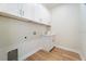 Bright laundry room features wooden tile flooring, white cabinets, a utility sink, and a washing machine hook-up at 13356 Rayburn Ln, Port Charlotte, FL 33981