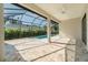 Screened in pool with a neutral-colored brick patio, ceiling fan, and tropical foliage at 13356 Rayburn Ln, Port Charlotte, FL 33981