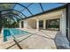 Outdoor enclosed pool area features brick paver flooring, a covered outdoor lounge area, and ceiling fans at 13356 Rayburn Ln, Port Charlotte, FL 33981