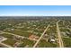 Expansive aerial view of a residential area with numerous homes surrounded by lush greenery and waterways at 13364 Rayburn Ln, Port Charlotte, FL 33981
