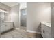 Bright bathroom featuring dual vanities, wood flooring, and a separate shower with marble-like tile at 13364 Rayburn Ln, Port Charlotte, FL 33981