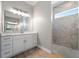 Modern bathroom with dual sink vanity, large mirror, and separate shower featuring beautiful marble-like tile at 13364 Rayburn Ln, Port Charlotte, FL 33981