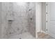 Bathroom with shower featuring stylish marble-look tile and a built-in niche and a glass door at 13364 Rayburn Ln, Port Charlotte, FL 33981