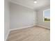 Bright bedroom with wood-look tile flooring, a window, and a white door to another room at 13364 Rayburn Ln, Port Charlotte, FL 33981