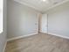 Neutral bedroom with wood-look tile flooring, white trim, and a door leading to another room at 13364 Rayburn Ln, Port Charlotte, FL 33981