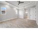 Bright, open bedroom featuring a tray ceiling, ceiling fan, and multiple windows for natural light at 13364 Rayburn Ln, Port Charlotte, FL 33981