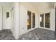 Covered patio with stone flooring, white walls, and sliding glass doors leading to the home's interior at 13364 Rayburn Ln, Port Charlotte, FL 33981