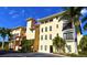 Beautiful condo complex with mature palm trees and vibrant yellow exterior at 1340 Rock Dove Ct # 143, Punta Gorda, FL 33950