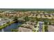 Aerial view of home with waterfront in a tropical community with mature palm trees at 1706 Fountain View Cir, Venice, FL 34292