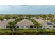 Scenic aerial view of a tranquil community featuring charming homes, a serene lake, and lush palm trees at 1706 Fountain View Cir, Venice, FL 34292