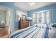 Comfortable bedroom featuring two beds, blue accents, a dresser with a tv and natural light at 1706 Fountain View Cir, Venice, FL 34292
