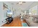 Open-concept living room with hardwood floors, comfortable seating, and abundant natural light at 1706 Fountain View Cir, Venice, FL 34292
