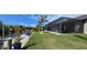 Landscaped backyard with a screened-in pool, dock, and lush greenery offers a perfect outdoor living space at 17350 Bayharbor Cir, Port Charlotte, FL 33948