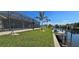 Beautiful canal-front property with a screened-in pool, lush lawn, and private boat dock for endless outdoor enjoyment at 17350 Bayharbor Cir, Port Charlotte, FL 33948