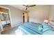 Bright bedroom with ceiling fan, adjacent bathroom, carpeted floors, and coastal decor at 17350 Bayharbor Cir, Port Charlotte, FL 33948