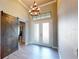 This home features an elegant foyer with grand ceilings, a decorative chandelier, and a modern sliding barn door at 17350 Bayharbor Cir, Port Charlotte, FL 33948