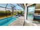 Relaxing poolside with a view; screened-in lanai features comfortable seating and a tranquil ambiance at 17350 Bayharbor Cir, Port Charlotte, FL 33948