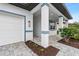 Covered entryway with paver walkway and white garage door at 1890 Sunset Preserve Way, Port Charlotte, FL 33953