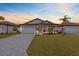 New construction home with paver driveway and landscaped lawn at 1890 Sunset Preserve Way, Port Charlotte, FL 33953