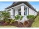 Exterior view of a house featuring a covered porch and manicured landscaping at 1890 Sunset Preserve Way, Port Charlotte, FL 33953