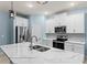 Modern kitchen with white cabinets, quartz countertops, and stainless steel appliances at 1890 Sunset Preserve Way, Port Charlotte, FL 33953