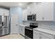 Modern kitchen with white cabinets, quartz countertops, and stainless steel appliances at 1890 Sunset Preserve Way, Port Charlotte, FL 33953