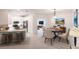 Open-concept space with a dining area and kitchen featuring modern lighting and stainless steel appliances at 1912 Saddlewood Cir, Port Charlotte, FL 33953