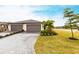 Charming home showcasing a well-manicured lawn, a gray brick driveway and an attached two-car garage at 1912 Saddlewood Cir, Port Charlotte, FL 33953