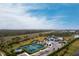 Panoramic aerial view of the tennis courts showcases the community clubhouse and surrounding landscape of this great neighborhood at 1912 Saddlewood Cir, Port Charlotte, FL 33953