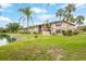 Exterior shot of a well-maintained condo building with lush green landscaping and waterfront views at 19505 Quesada Ave # Aa107, Port Charlotte, FL 33948